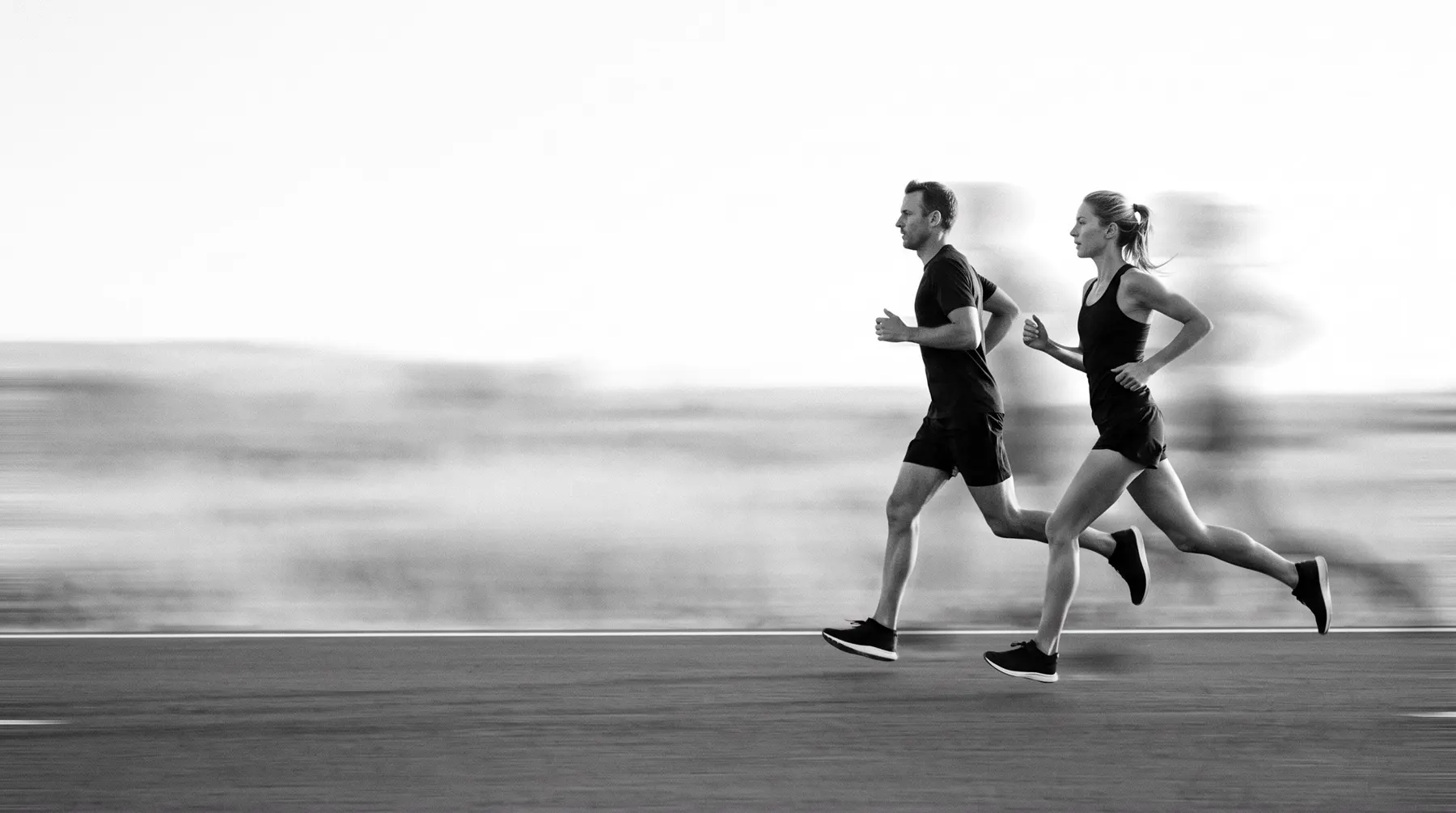 Two runners on a road, black and white shot